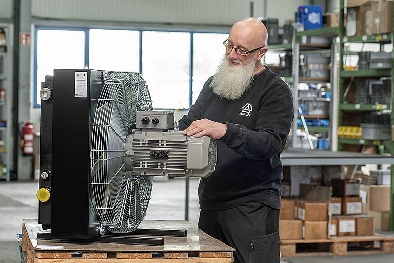 Ralf Fuhrmann begutachtet einen Kühler von Hennlich in der Werkstatt