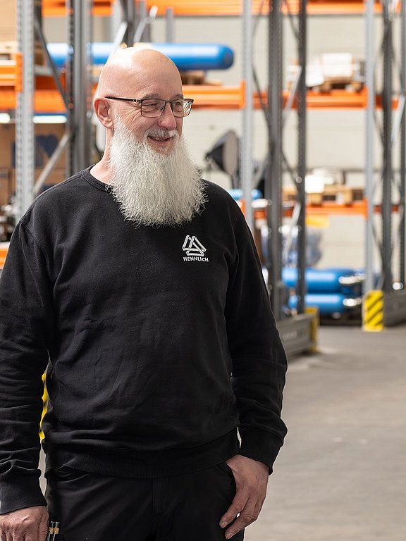 Drei Mitarbeiter der Werkstatt sprechen über einen Auftrag im Lager