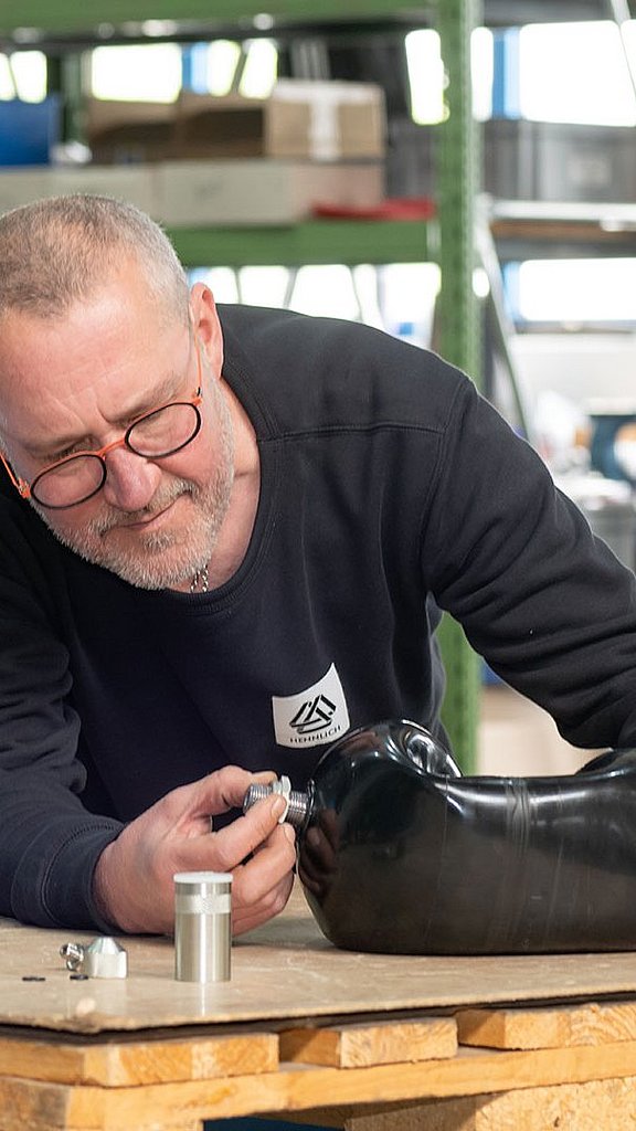 Mitarbeiter montiert ein Ventil an die Gummiblase für Blasenspeicher