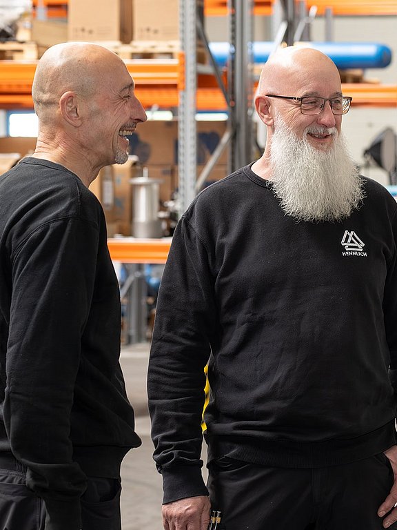 Drei Mitarbeiter unterhalten sich über einen Auftrag im Lager