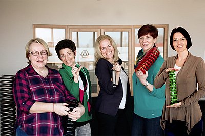 Mitarbeiter halten Produkte aus der Federntechnik