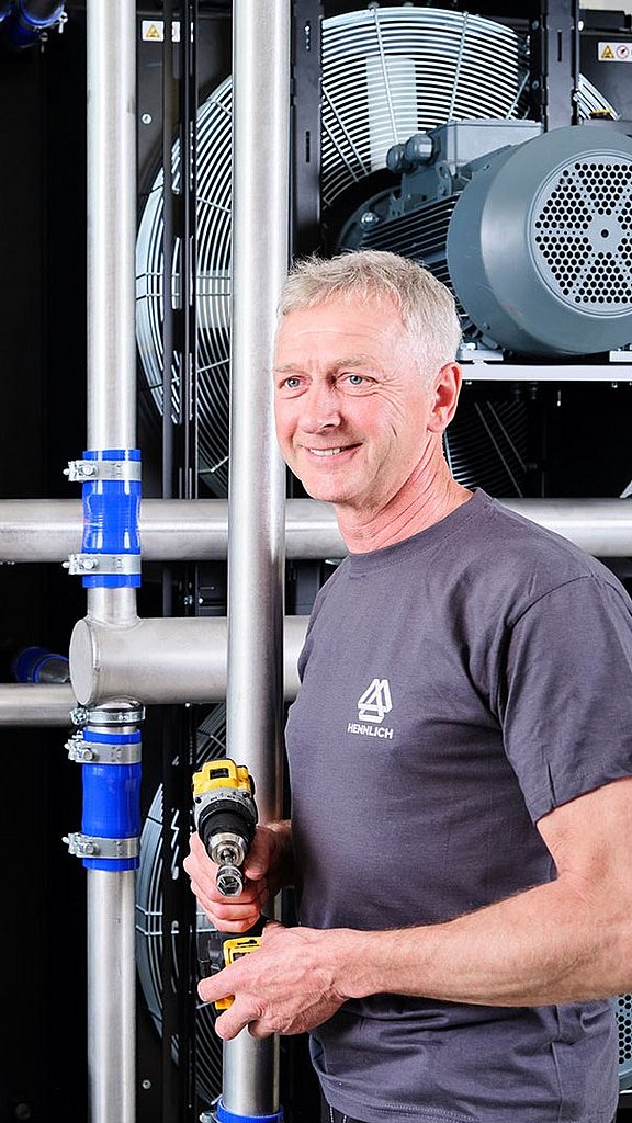 Zwei Mitarbeiter stehen vor einer Kühlerwand