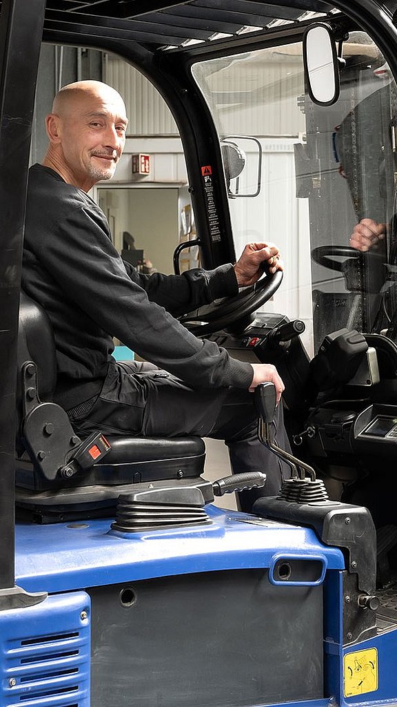 Mitarbeiter steuert einen Gabelstapler mit Blasenspeichern im Lager